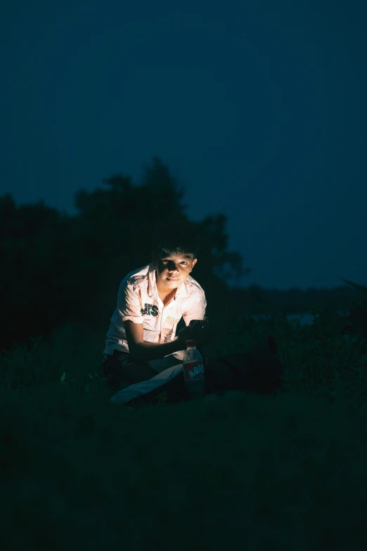 a young man in the dark crouches down