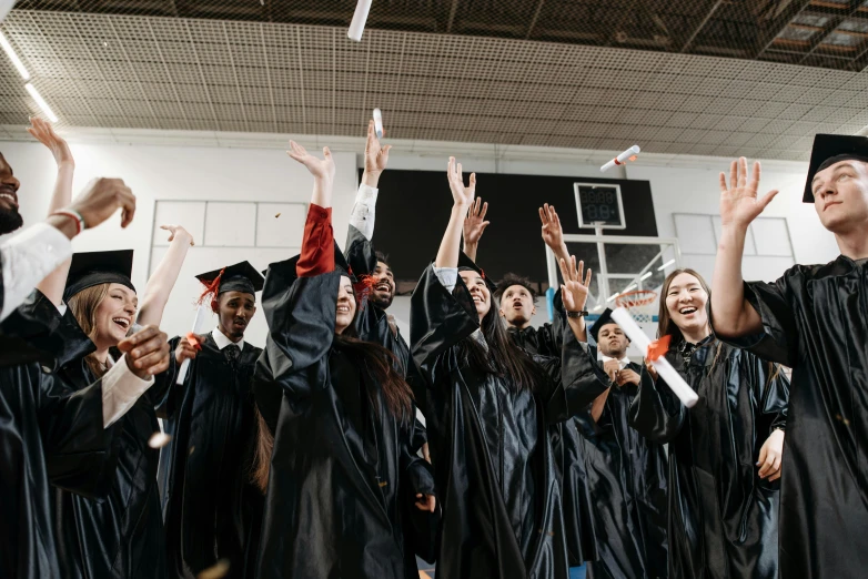 graduates throwing their caps and papers in the air