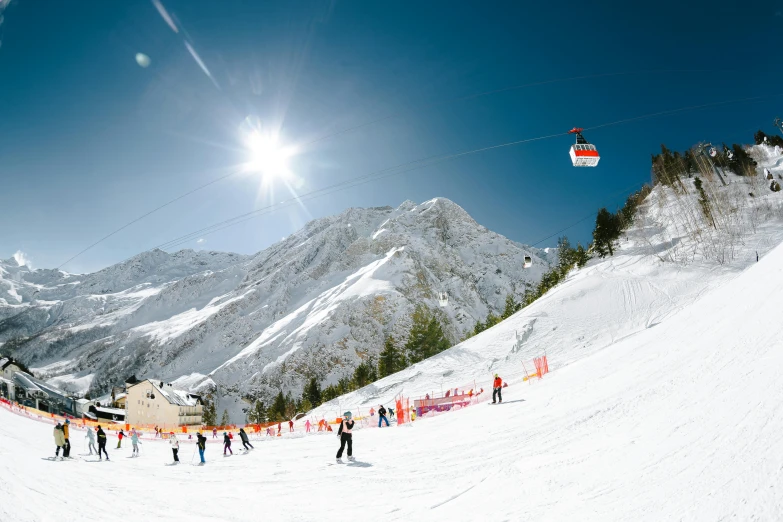 skiers at the base of a ski resort near mountain range