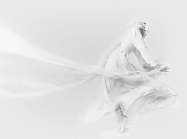 a bride is dancing while she's veil blowing in the air