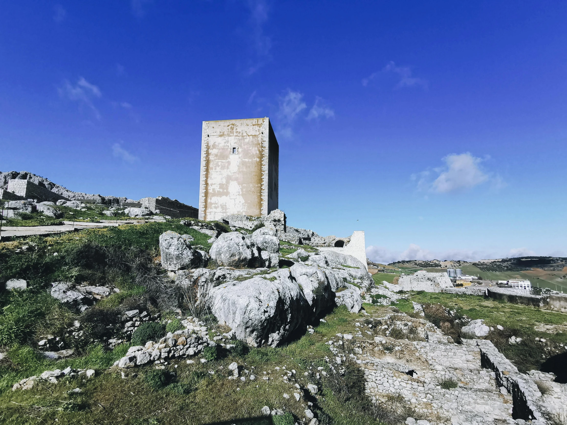 an old tower on a hill surrounded by rocks