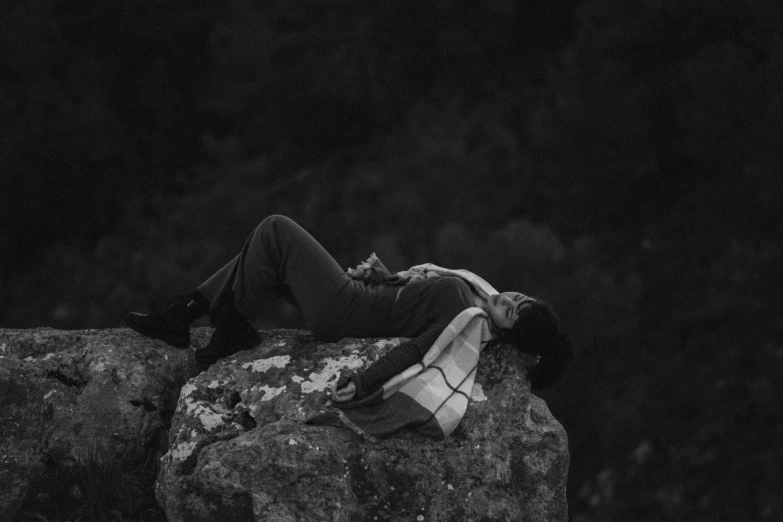 a man laying on top of a rock