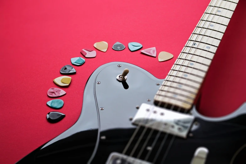 a guitar has small, colorful picks and a pick