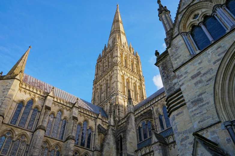 a tall tower with clock stands over an old building