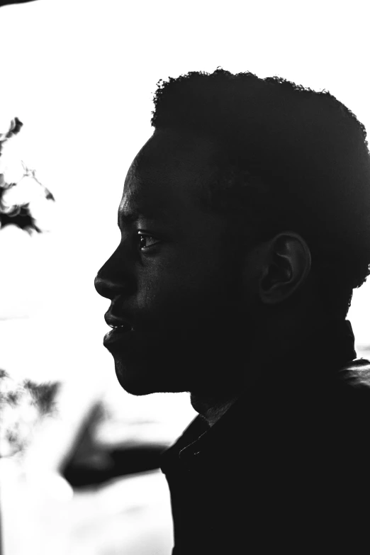 black and white pograph of a person with a potted plant behind them