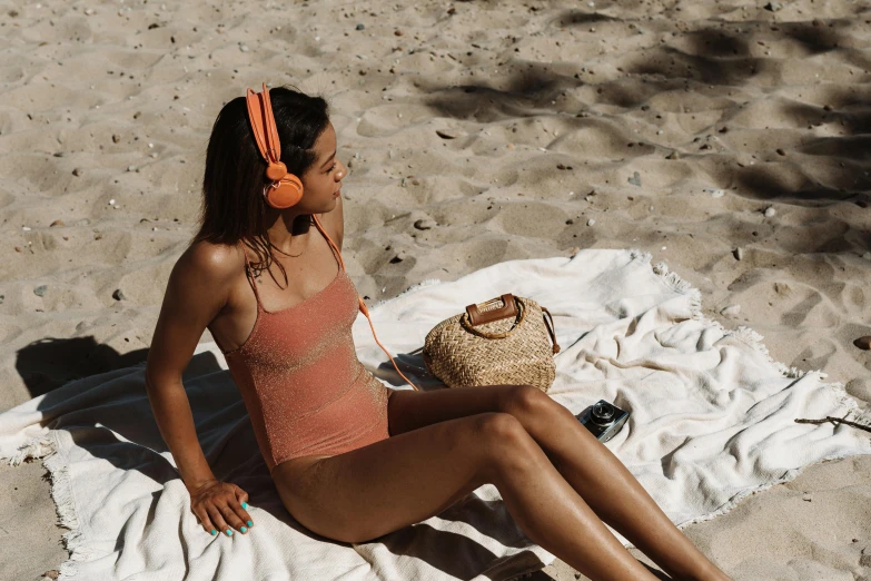 a woman sitting on top of a sandy beach