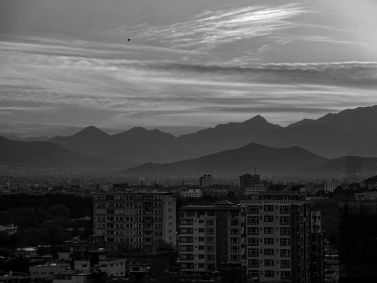 black and white pograph of cityscape with mountains in the background