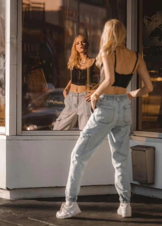 woman with ripped pants and crop top looking in window