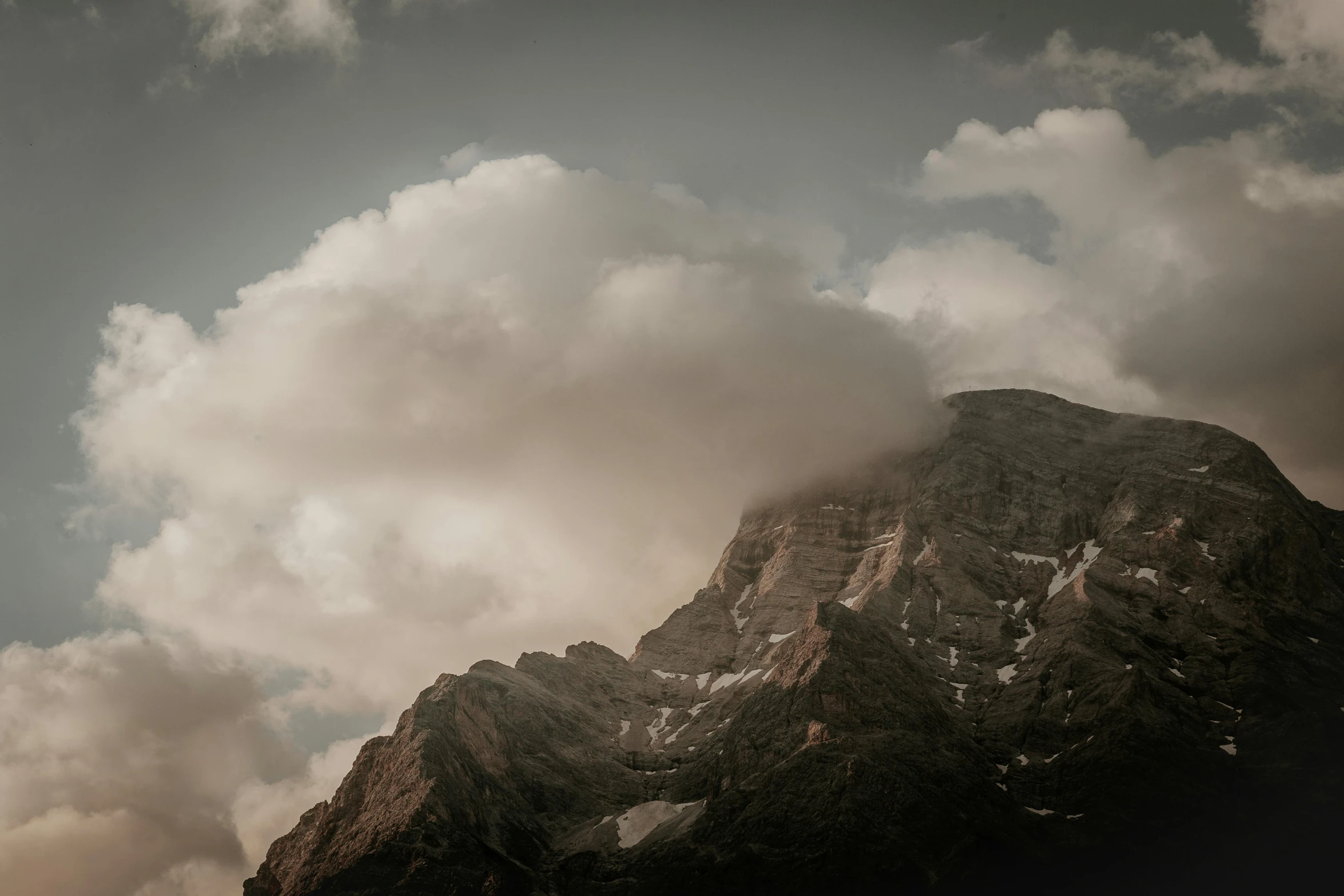 some clouds hang over a large mountain range