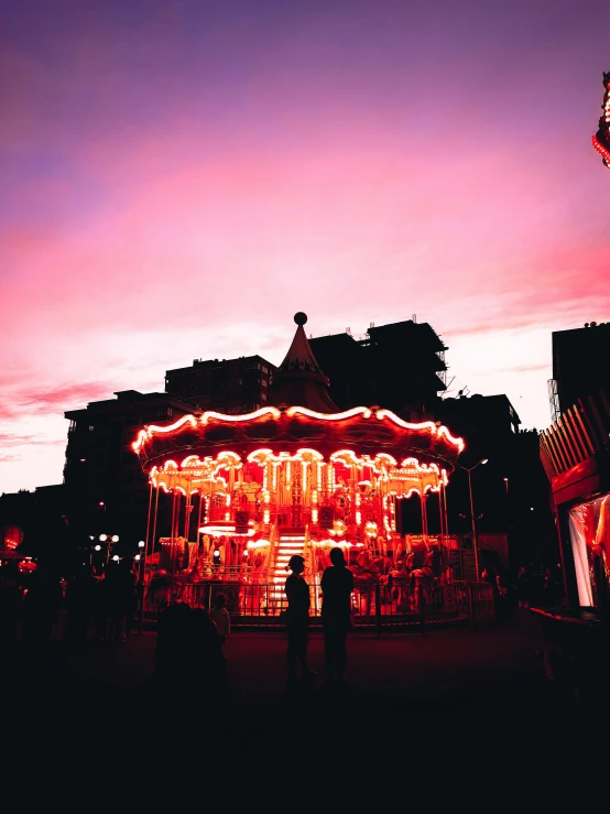 a carousel with a lot of lights near the building