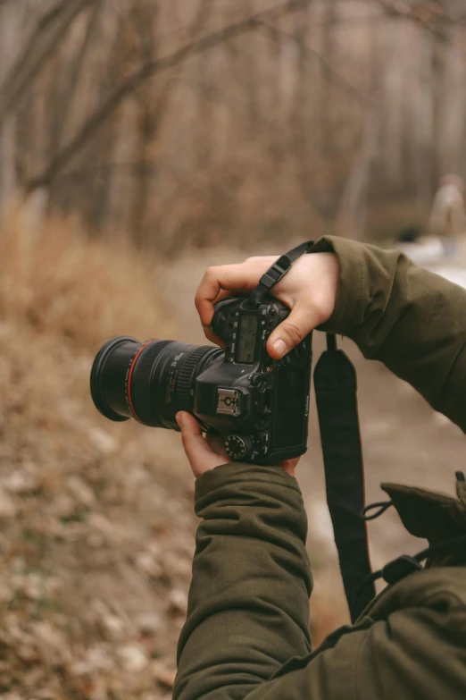 a person holding up a digital camera