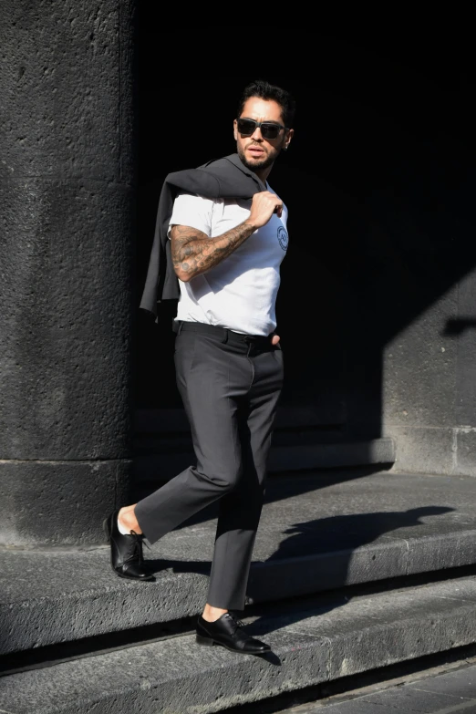 a man standing on steps with a black and white shirt