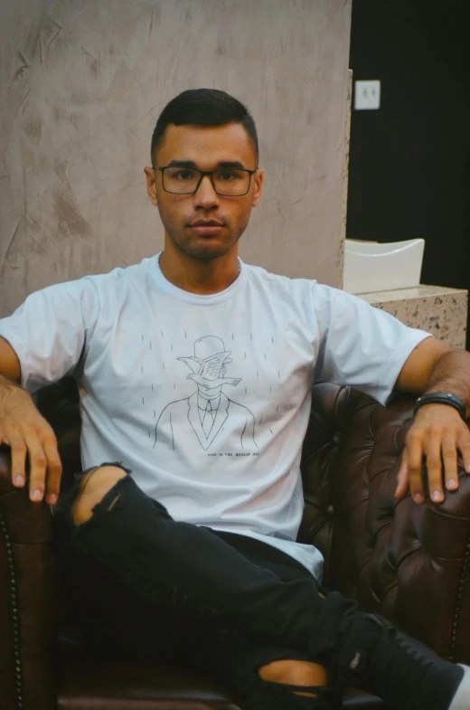 a man sitting in a chair wearing glasses