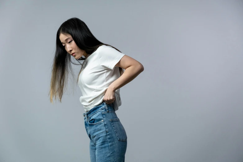 a girl standing wearing jeans with her hands in her pockets