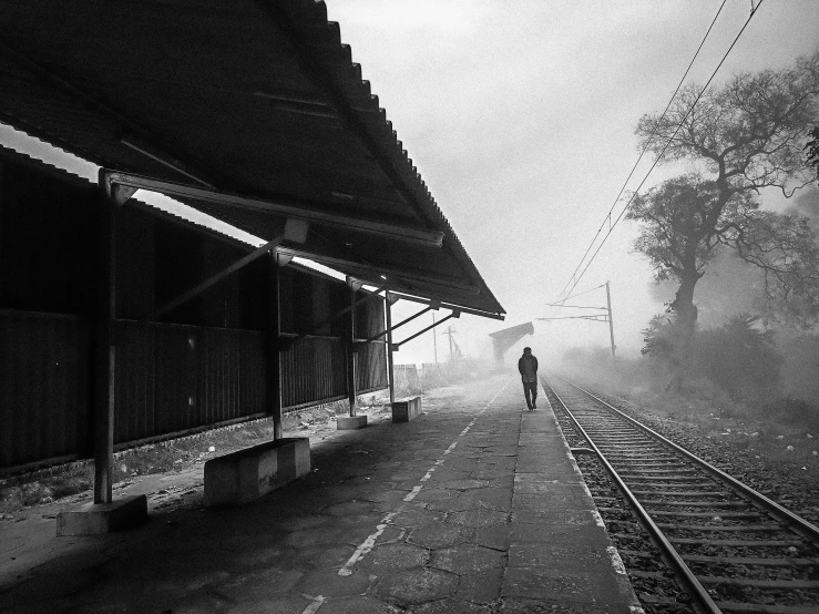 a person standing on the side of railroad tracks