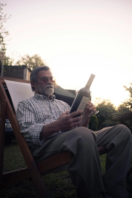 a man reading a book while sitting in a chair