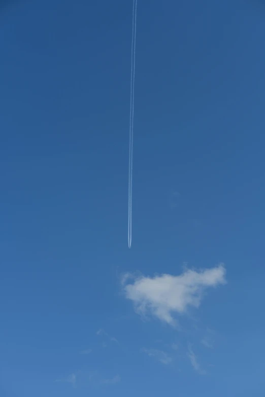 an airplane is flying in the sky and it was trailing an arrow