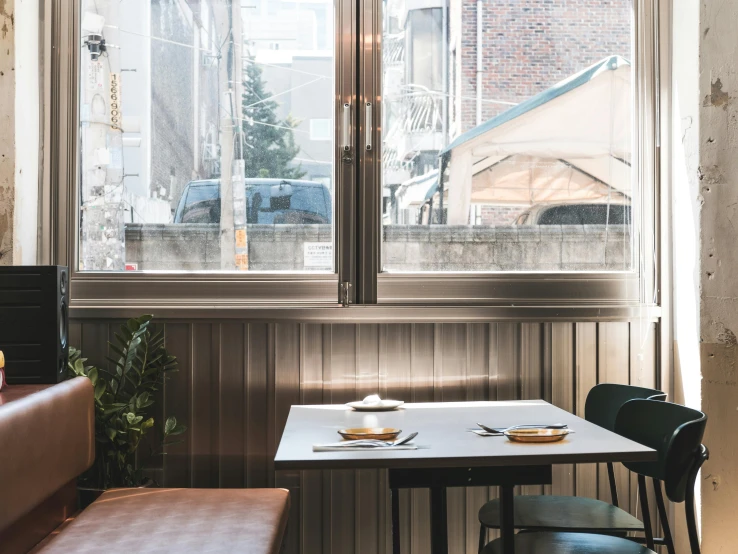 a table and some seats near large windows