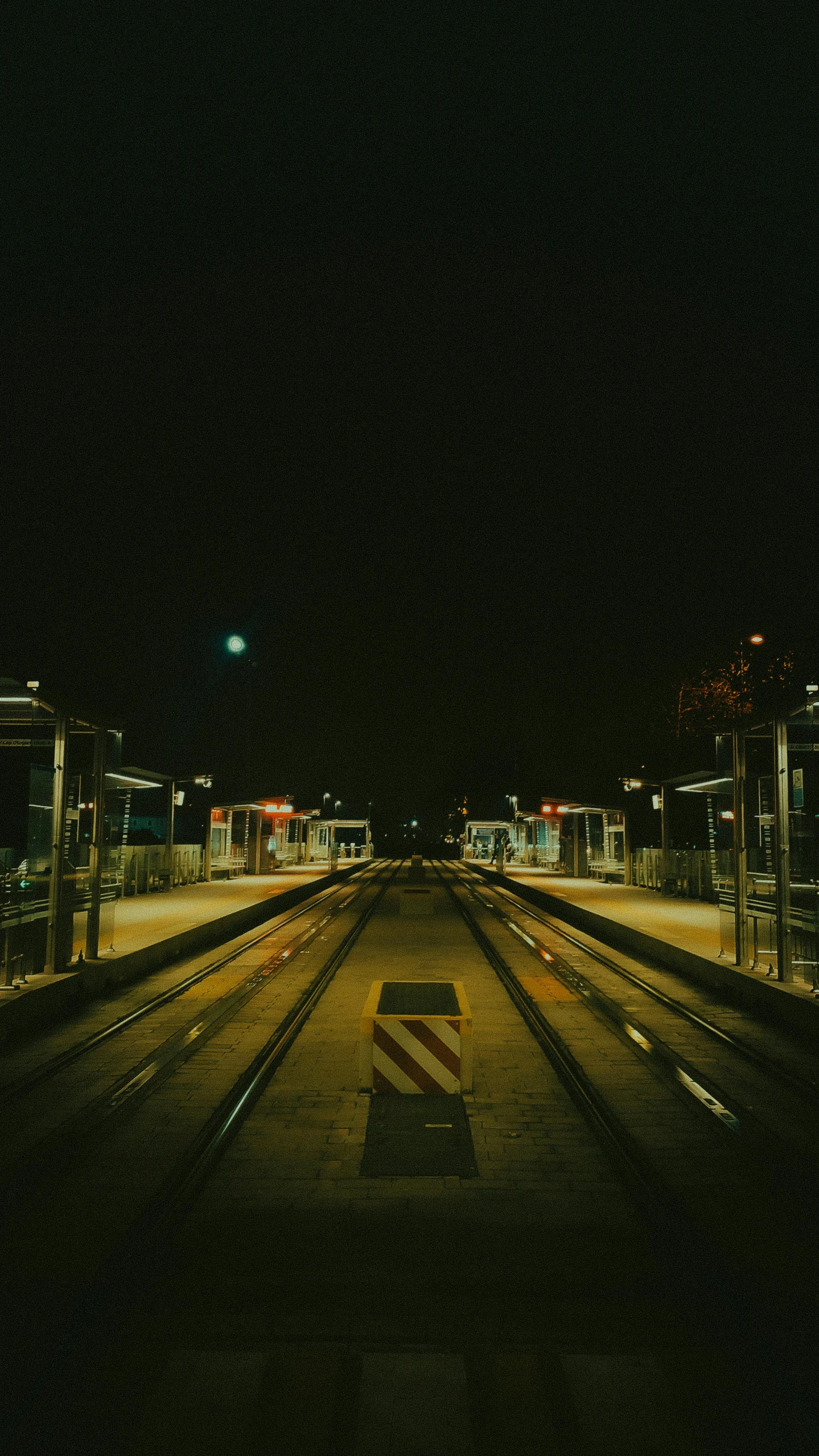 the po has two cars driving along the railroad tracks at night