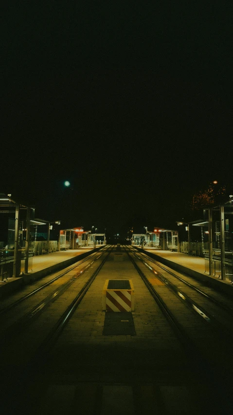 the po has two cars driving along the railroad tracks at night