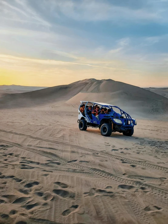 a group of people in a buggy traveling through the desert