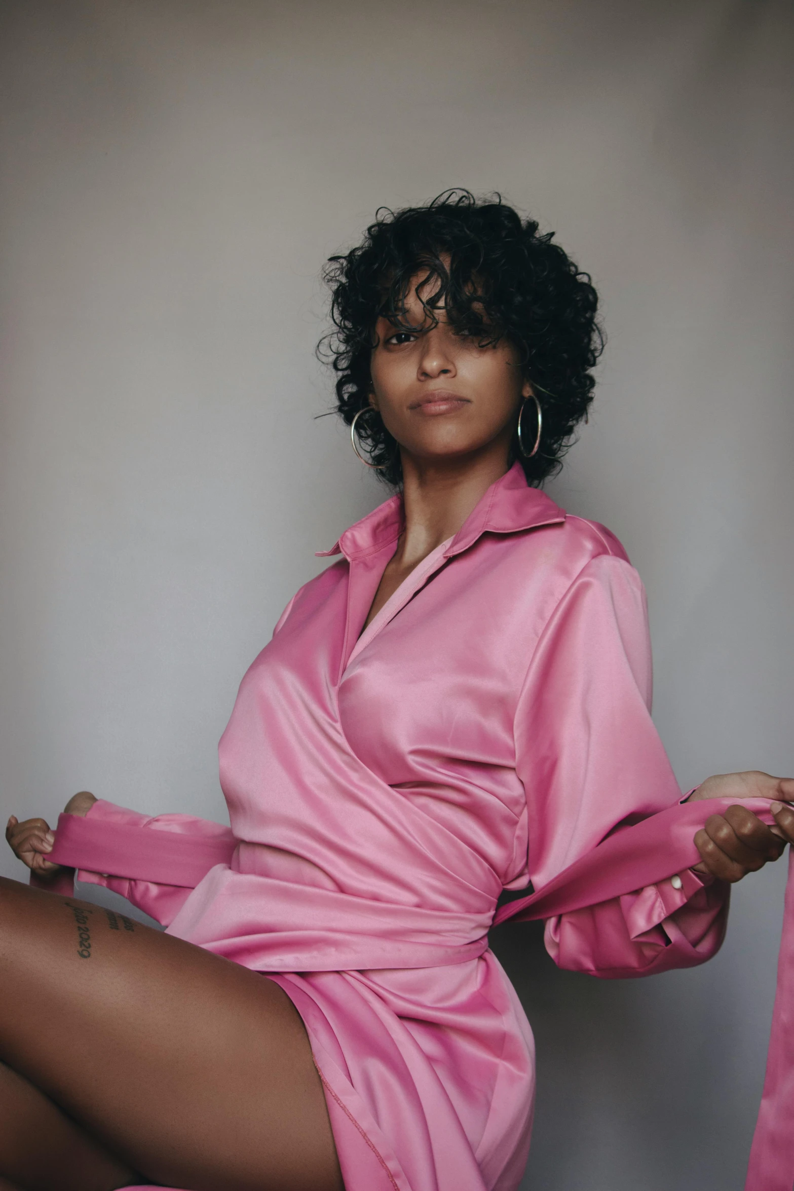 a woman in a pink shirt and skirt posing for the camera