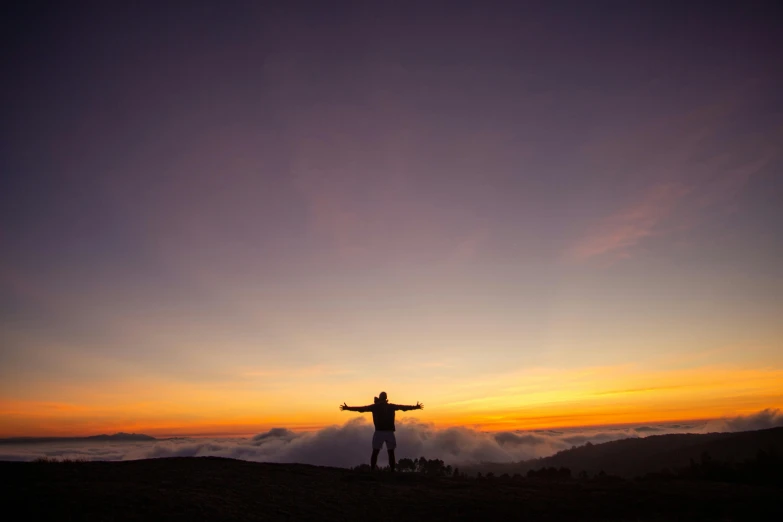 man standing on top of a mountain looking down