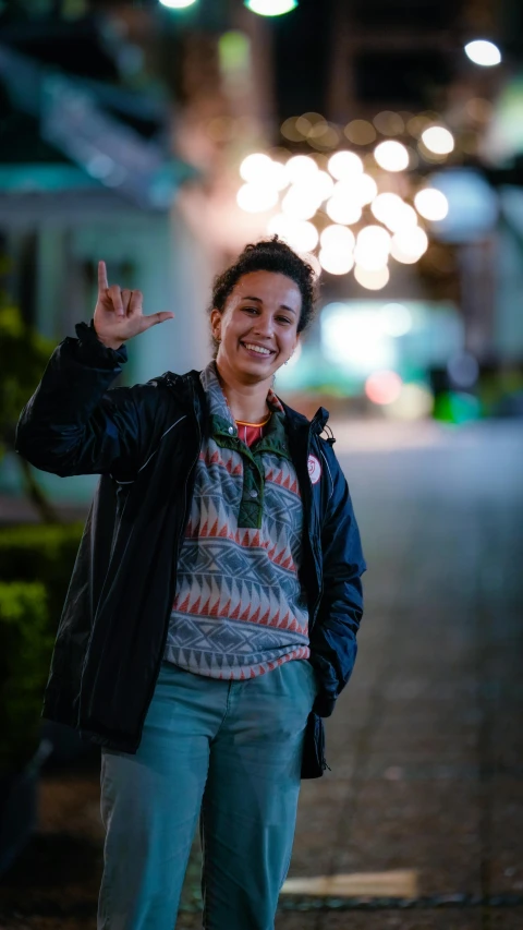 woman standing with her hands up and making the vulcan sign