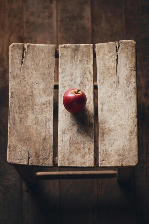 an apple is on a chair with no back