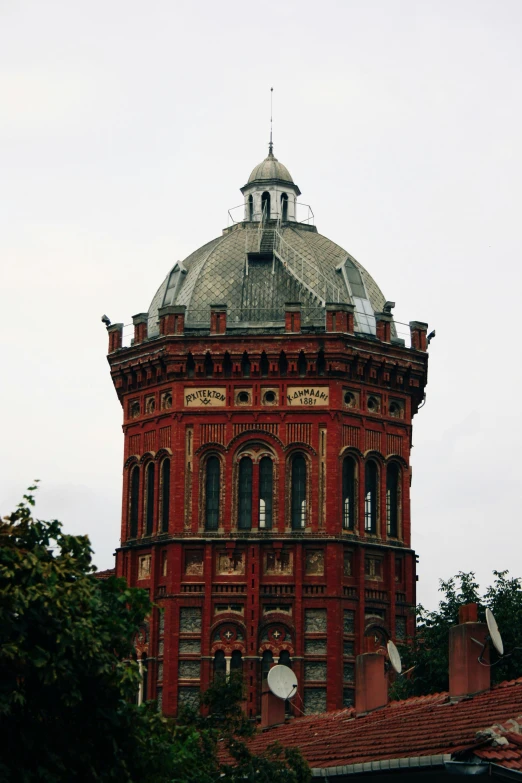 an old style red building with a round clock on top