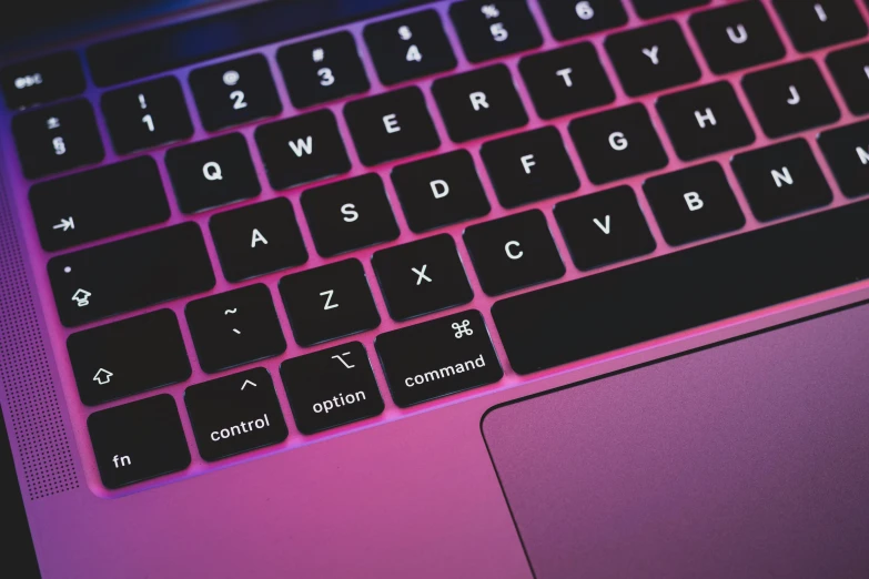 a black and pink keyboard on a dark laptop