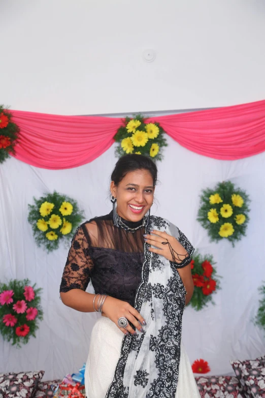 woman standing and smiling next to a decorated backdrop