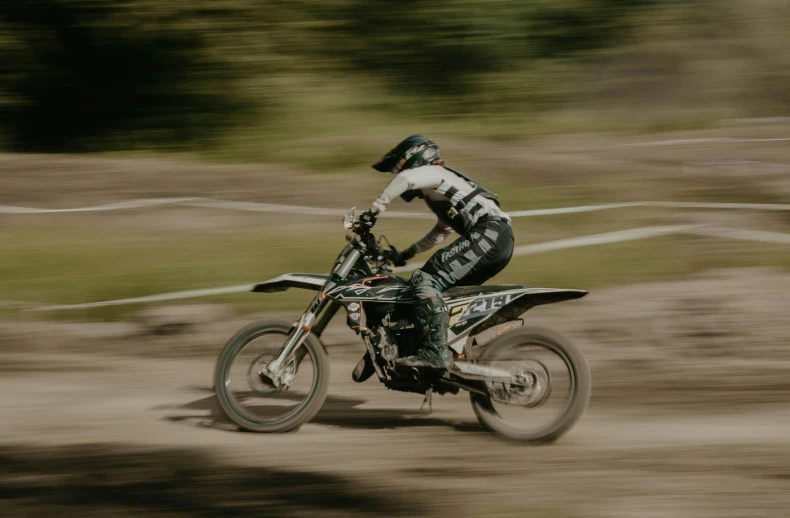 a man riding a dirt bike on top of a dirt field