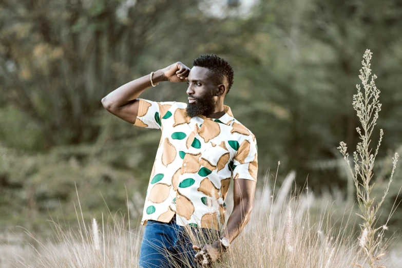 a man with a beard poses for the camera in a field