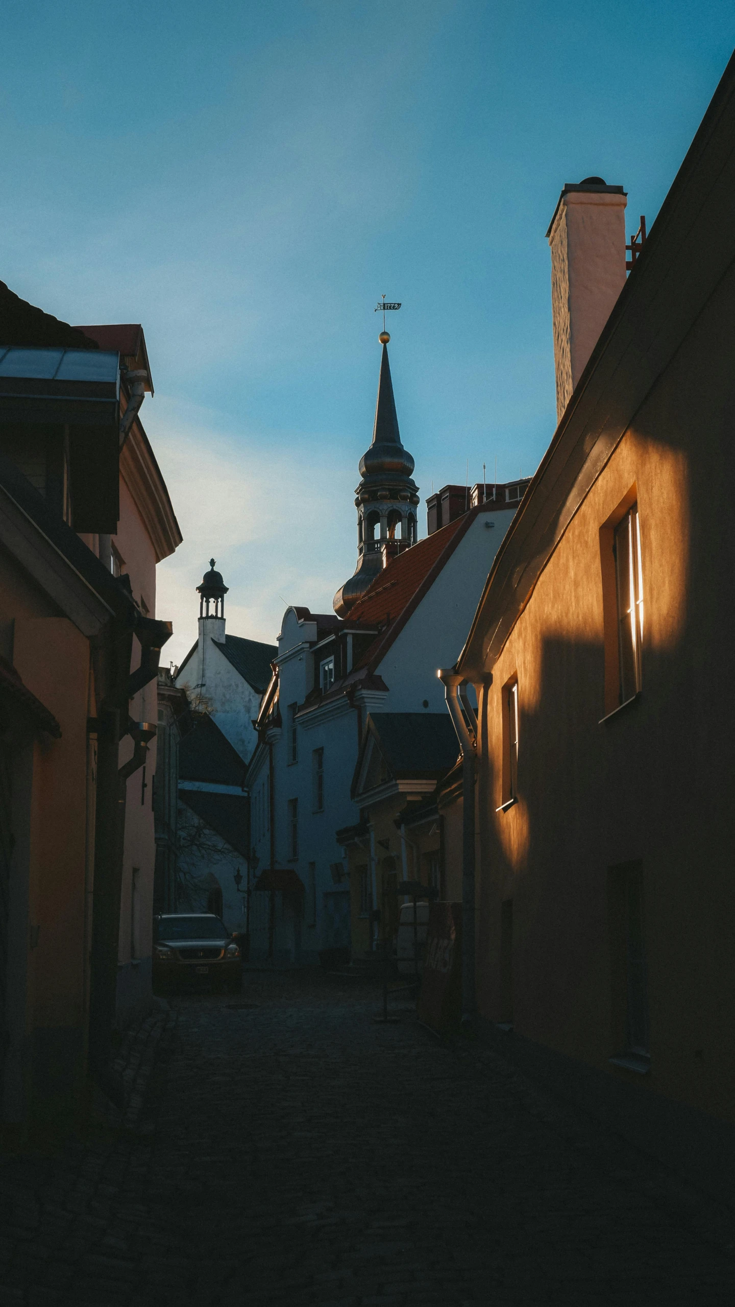 a narrow alley way with sun on the building