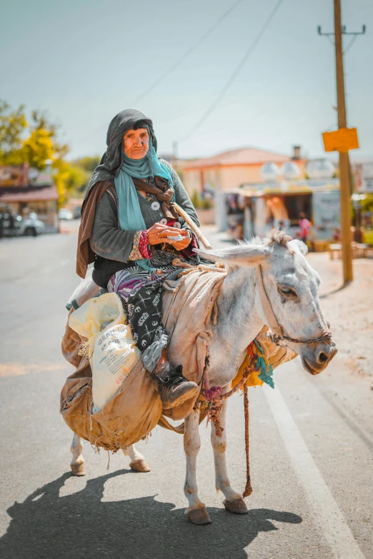 an older woman riding on the back of a white cow