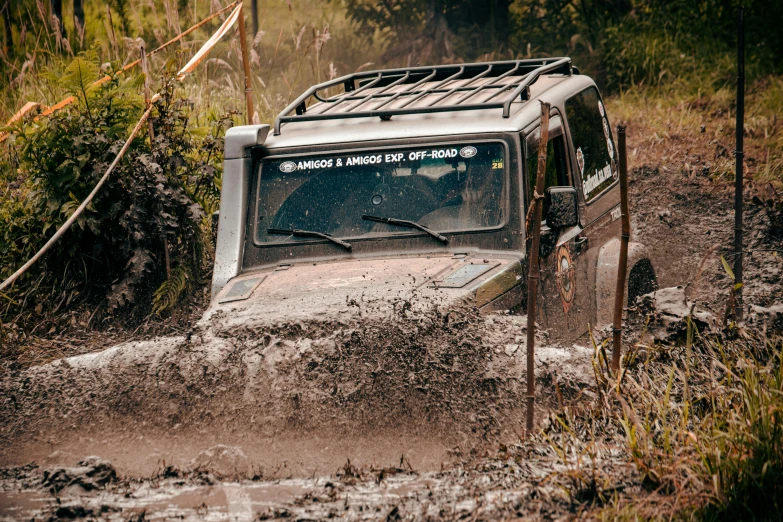 an off road vehicle drives through mud