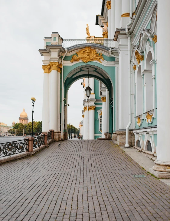 a brick path between two white buildings