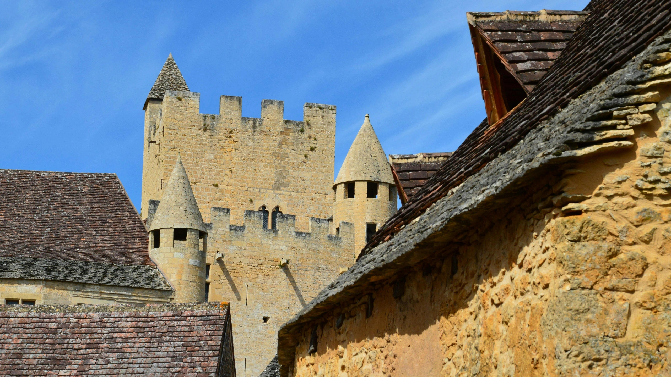 a view of an old castle wall with some old stone buildings