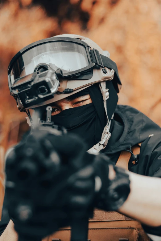 a man in motorcycle gear, with gloves and a gun