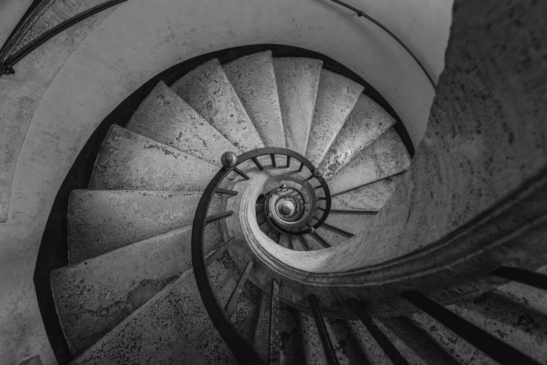 a spiral staircase in an underground passage with no rails