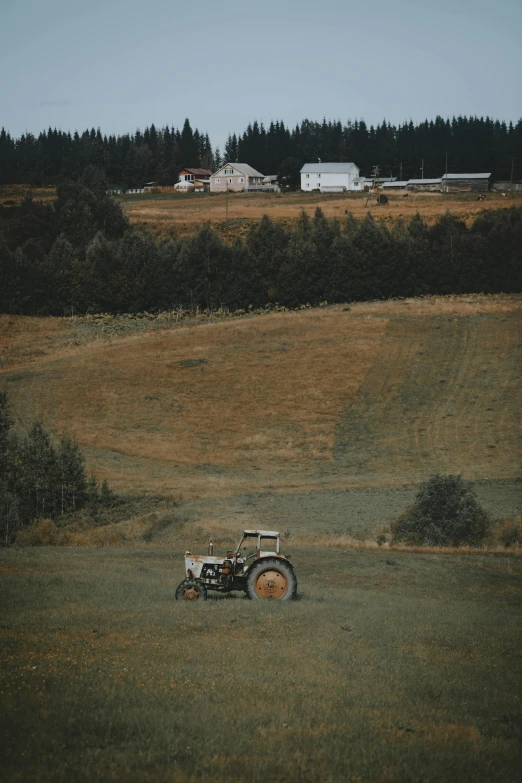 a tractor is parked on the side of a large field