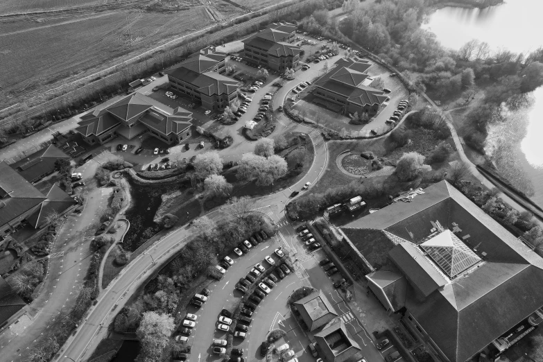 an aerial view of buildings, trees and water in black and white