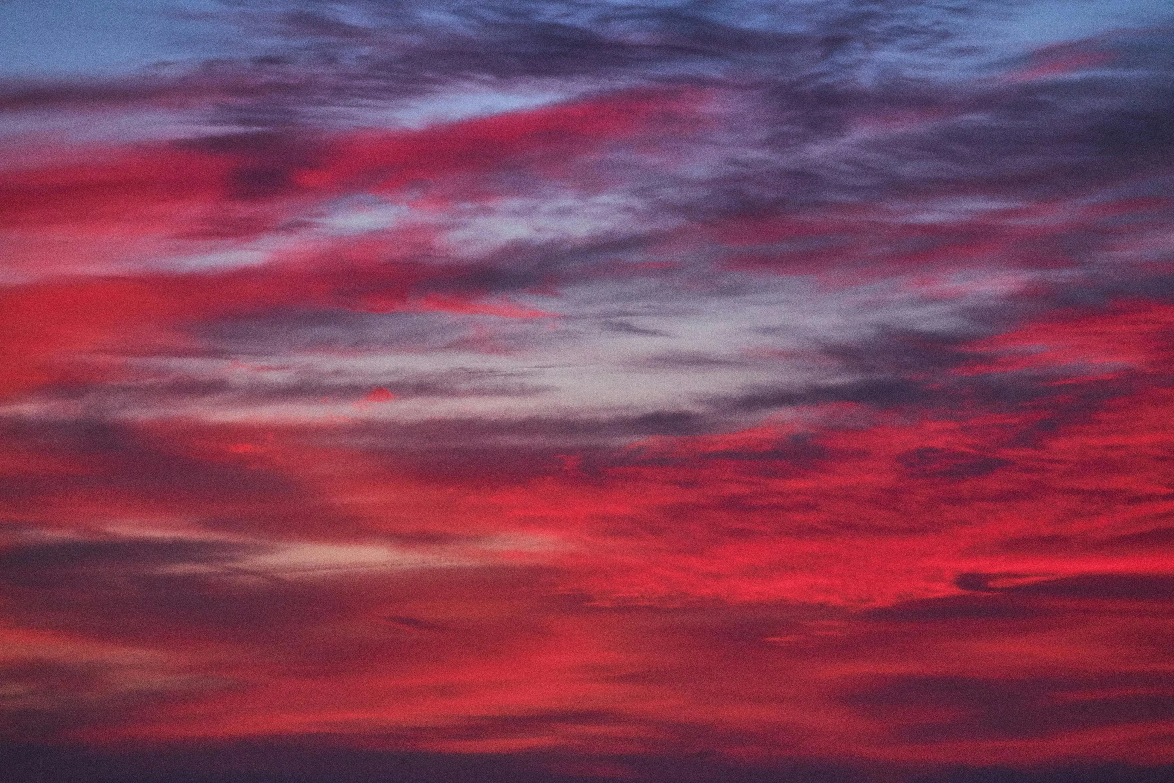 some clouds and a blue sky with a red glow