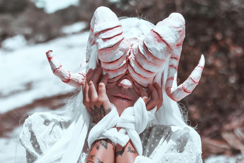 a man with white makeup and horns, looking through his eyes