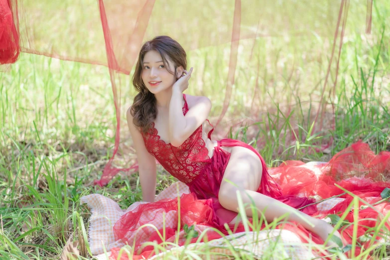 a woman sits on the grass and smiles at the camera