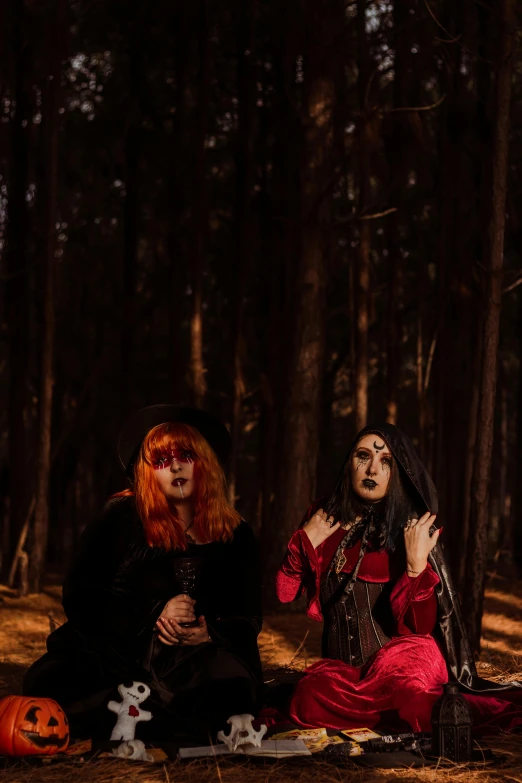 two people dressed up as witches in the woods