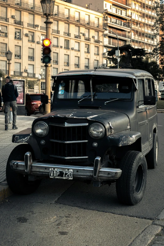 the antique car is parked in front of a street light