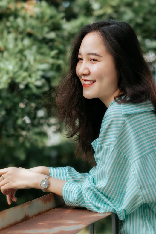 a woman is standing on a railing smiling