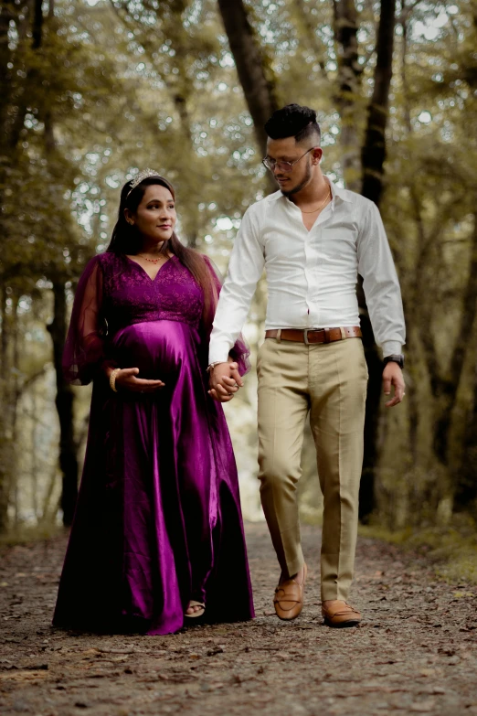 pregnant man walking with his woman down a path